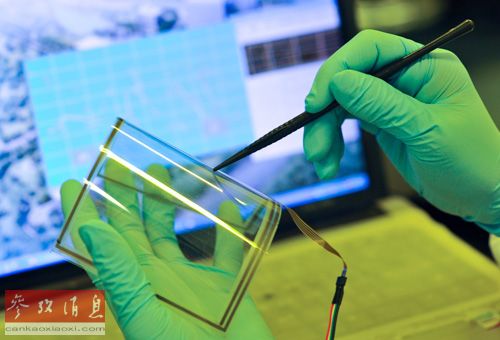 資料圖片：2013年1月24日，中科院重慶綠色智能技術研究院的一名研究人員在彎曲的單層石墨烯觸摸屏上進行書寫功能測試。新華社記者 劉潺 攝